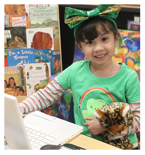 Student with St. Patrick's Day outfit with a laptop